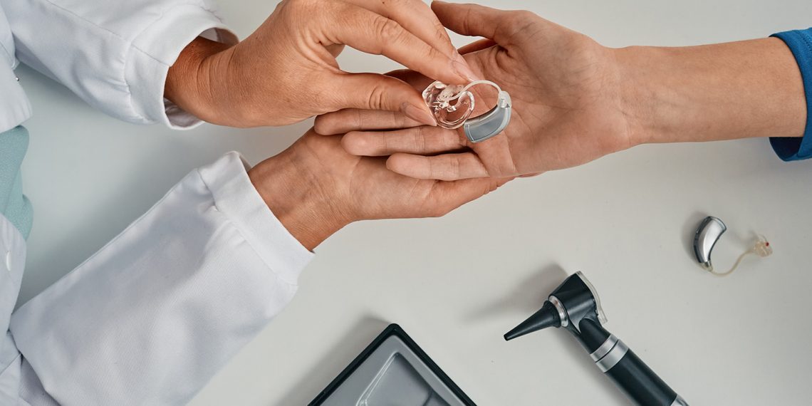 How do hearing aids help with Sensorineural Hearing Loss?